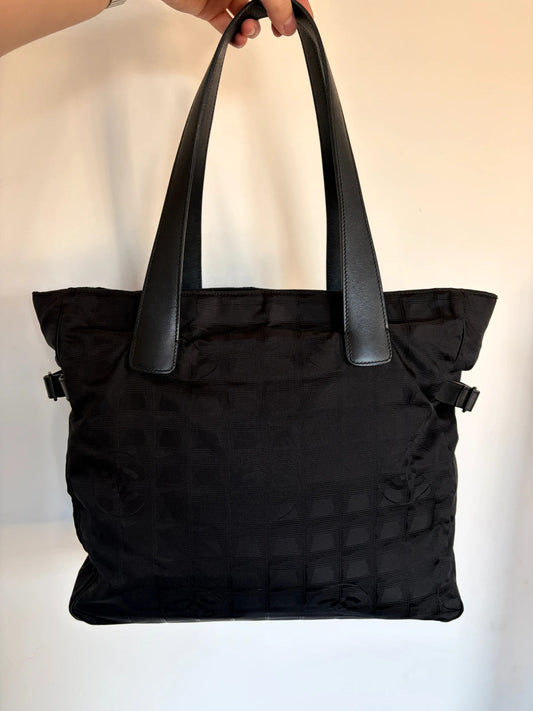 Chanel black shopping tote with woven CC jacquard pattern and smooth calfskin handles.