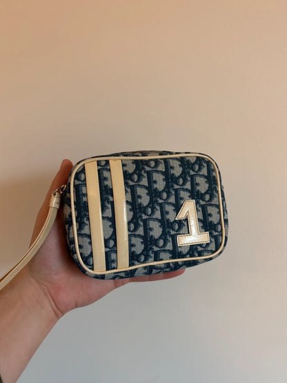 Dior cream and navy wristlet with Trotter monogram, patent leather appliqués, and silver zipper.