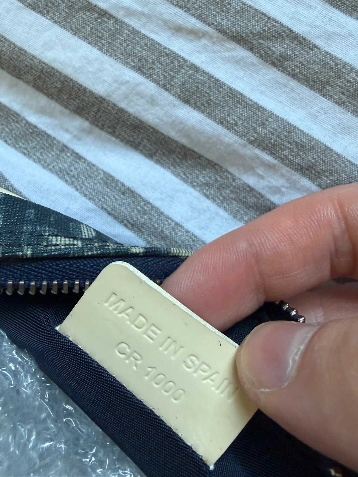 Dior cream and navy wristlet with Trotter monogram, patent leather appliqués, and silver zipper.
