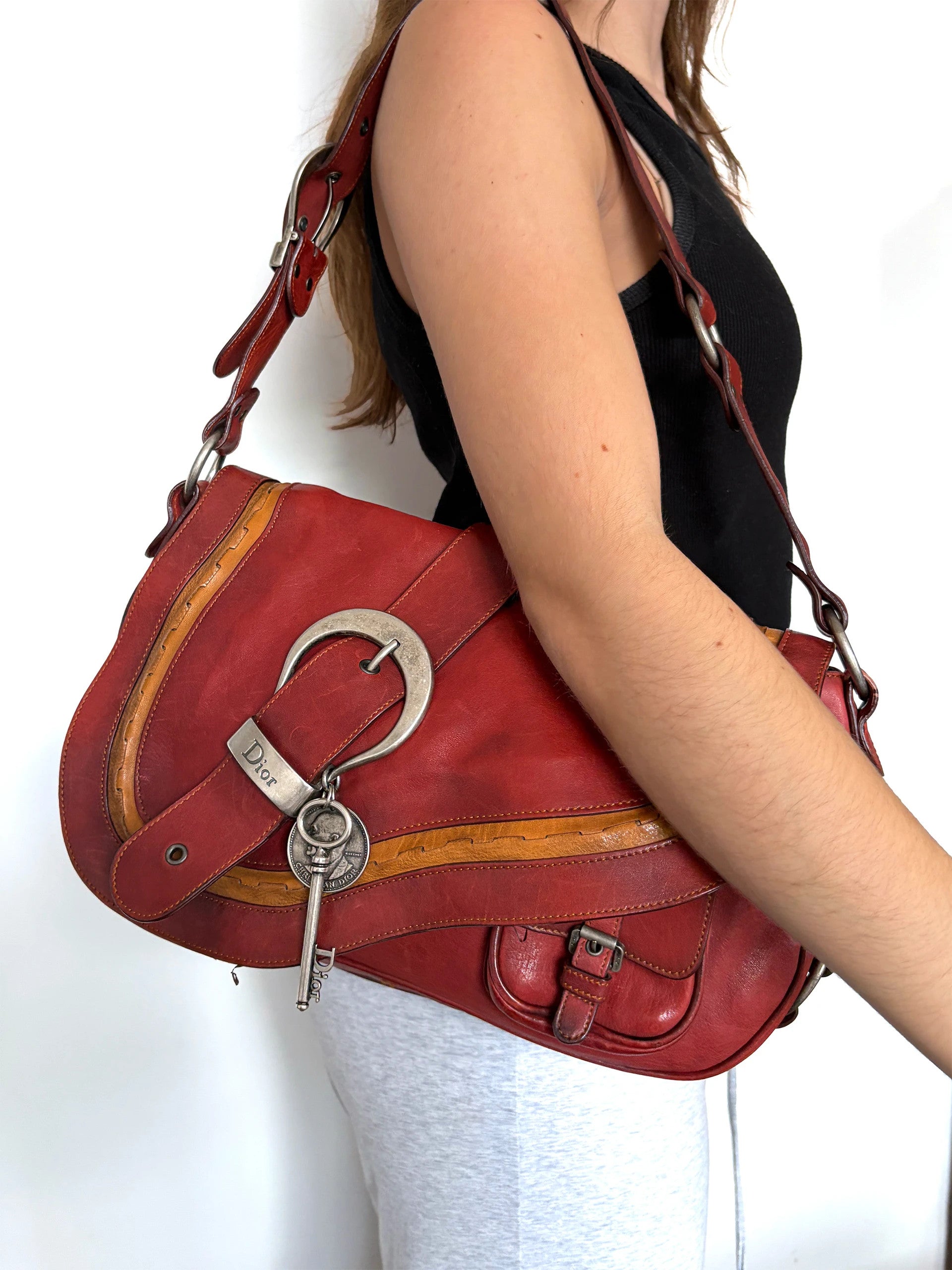 Christian Dior burgundy shoulder bag distressed calfskin leather with tan whipstitch and logo charms.
