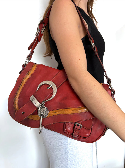 Christian Dior burgundy shoulder bag distressed calfskin leather with tan whipstitch and logo charms.