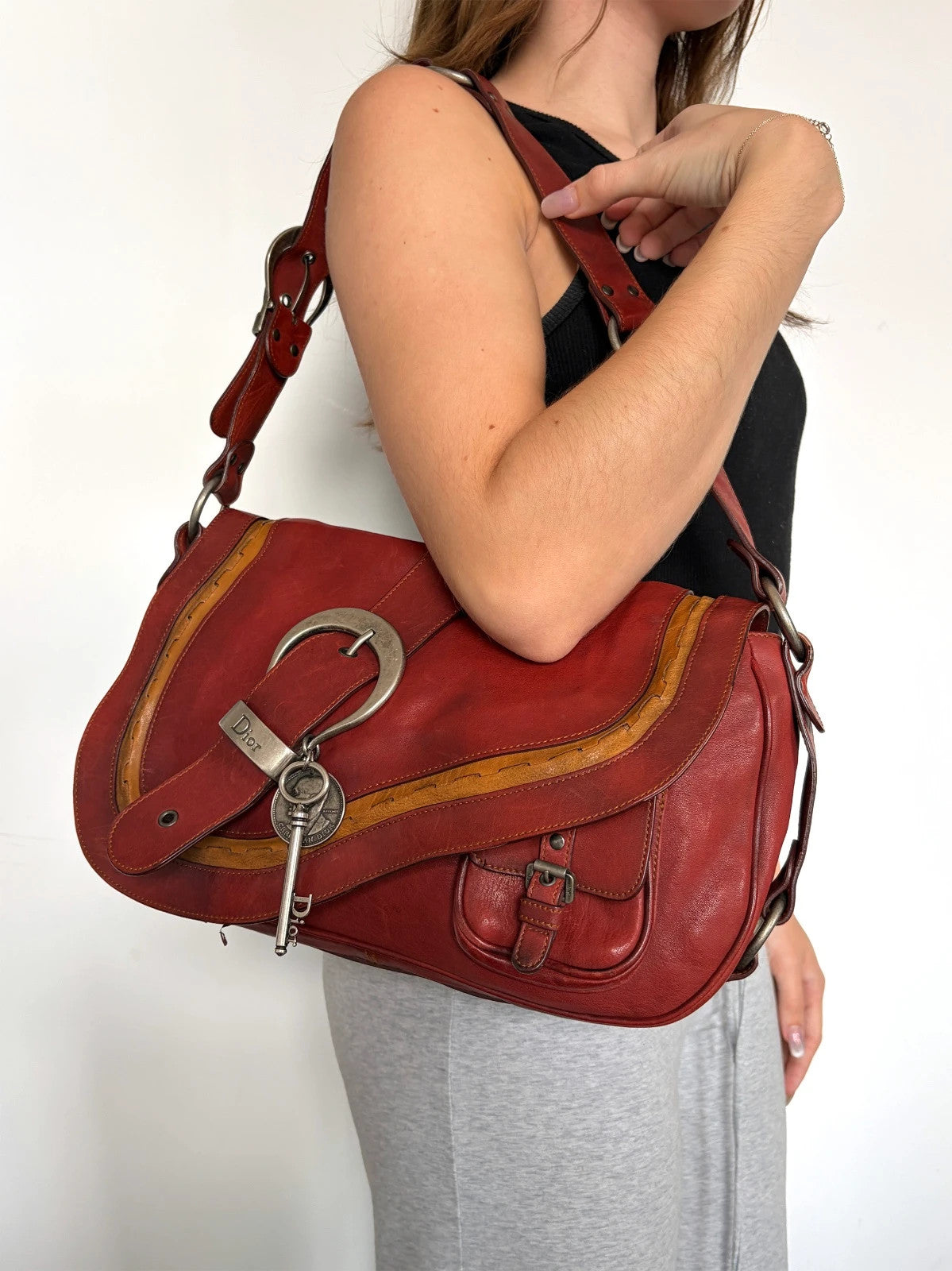 Christian Dior burgundy shoulder bag distressed calfskin leather with tan whipstitch and logo charms.