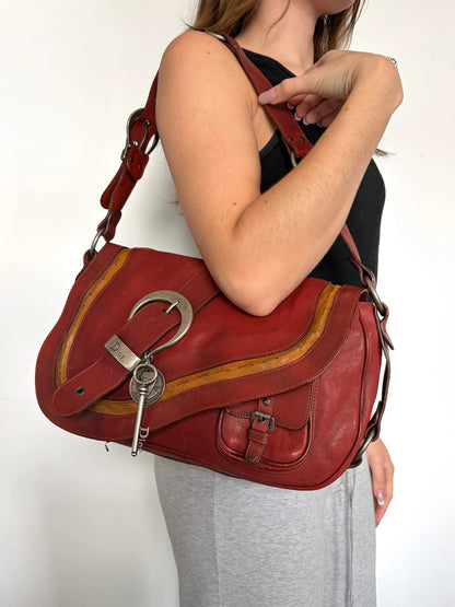 Christian Dior burgundy shoulder bag distressed calfskin leather with tan whipstitch and logo charms.