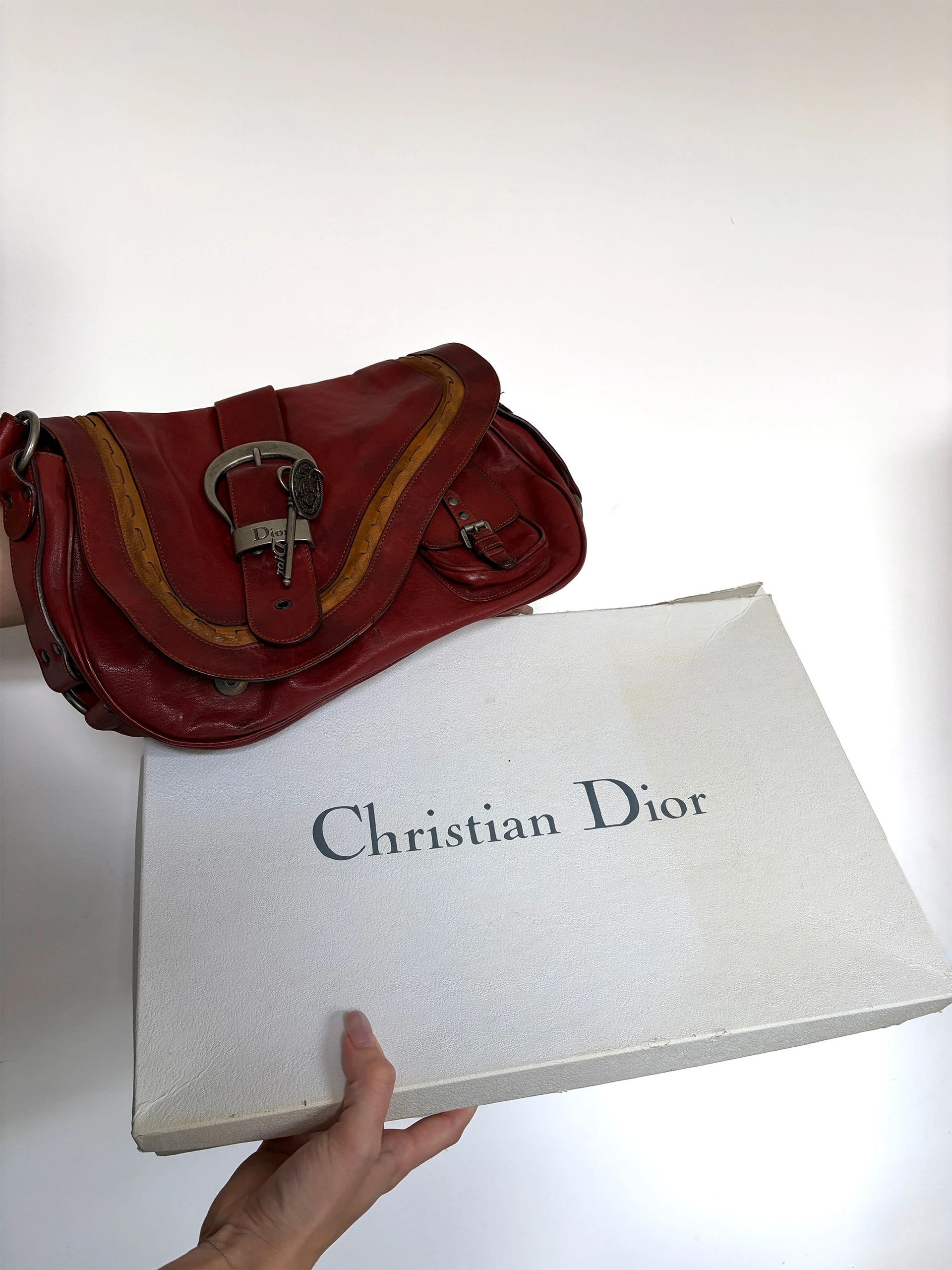 Christian Dior burgundy shoulder bag distressed calfskin leather with tan whipstitch and logo charms.