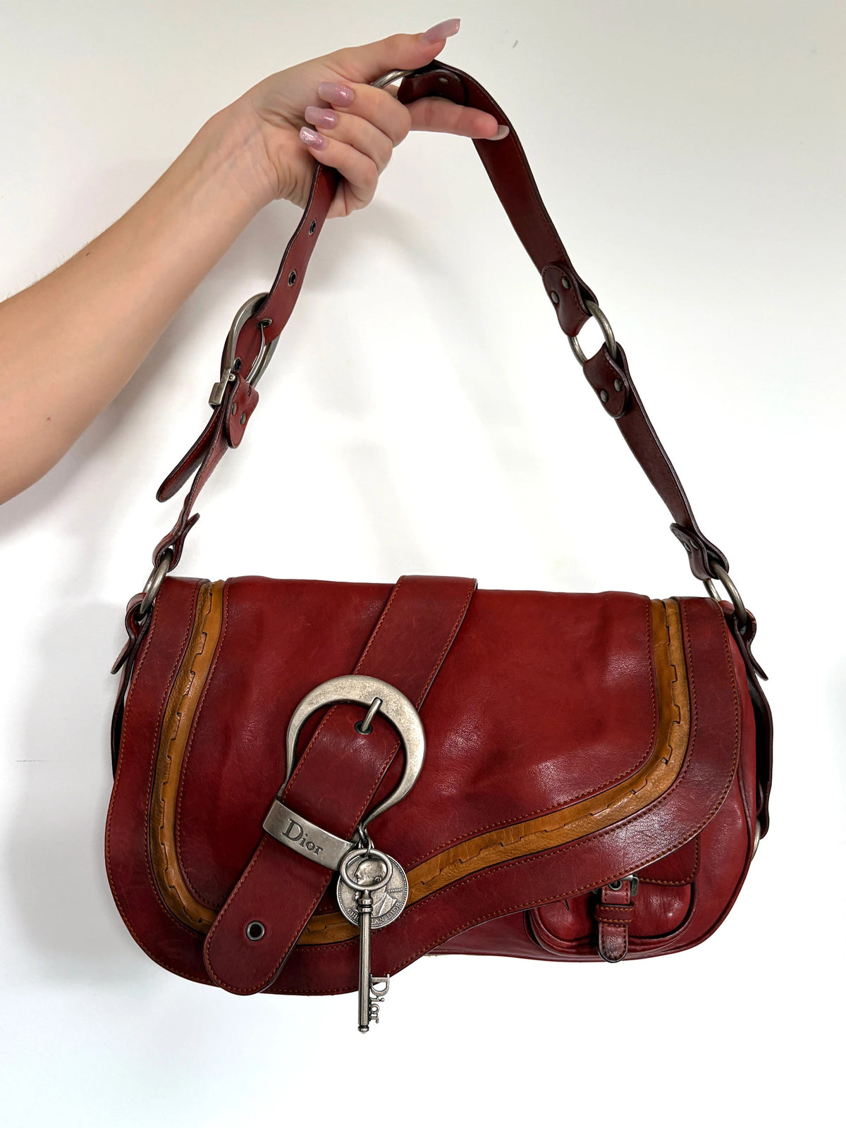 Christian Dior burgundy shoulder bag distressed calfskin leather with tan whipstitch and logo charms.