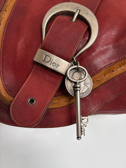 Christian Dior burgundy shoulder bag distressed calfskin leather with tan whipstitch and logo charms.