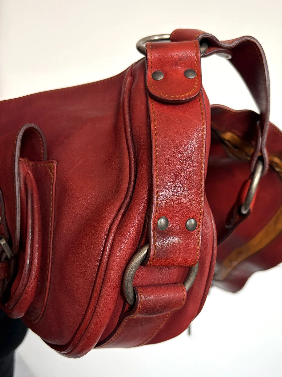 Christian Dior burgundy shoulder bag distressed calfskin leather with tan whipstitch and logo charms.