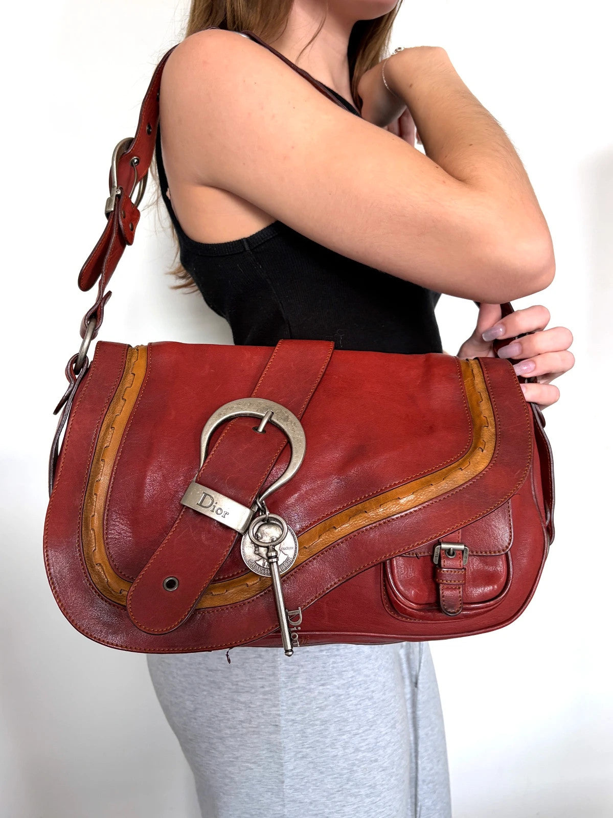 Christian Dior burgundy shoulder bag distressed calfskin leather with tan whipstitch and logo charms.