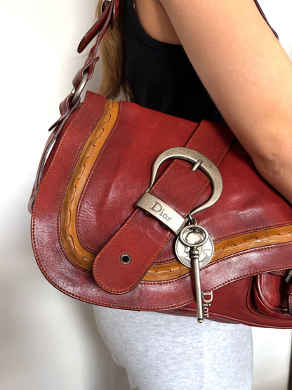 Christian Dior burgundy shoulder bag distressed calfskin leather with tan whipstitch and logo charms.