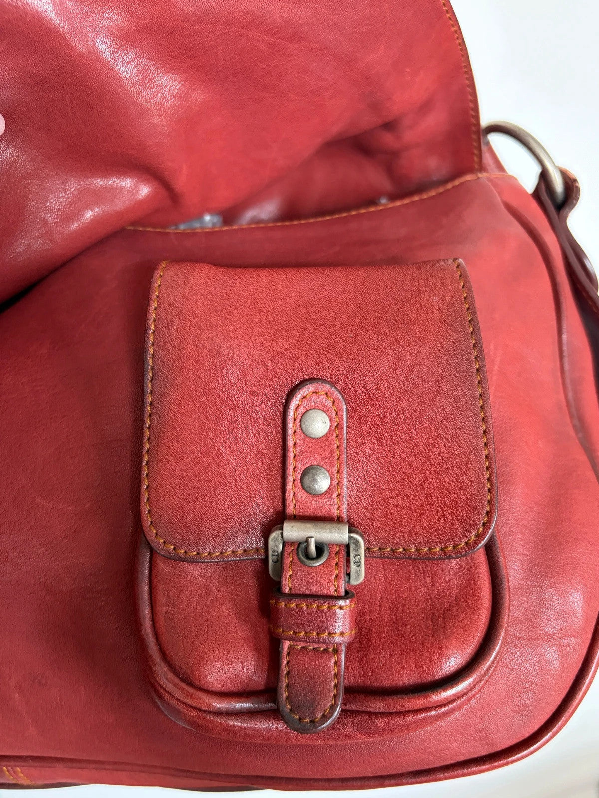 Christian Dior burgundy shoulder bag distressed calfskin leather with tan whipstitch and logo charms.