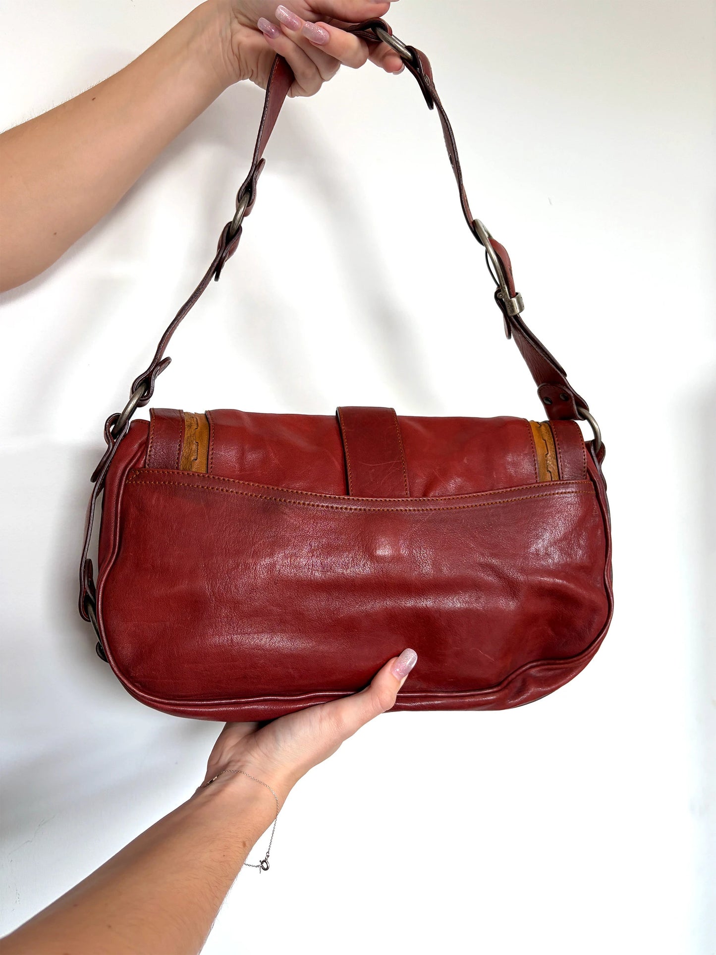 Christian Dior burgundy shoulder bag distressed calfskin leather with tan whipstitch and logo charms.