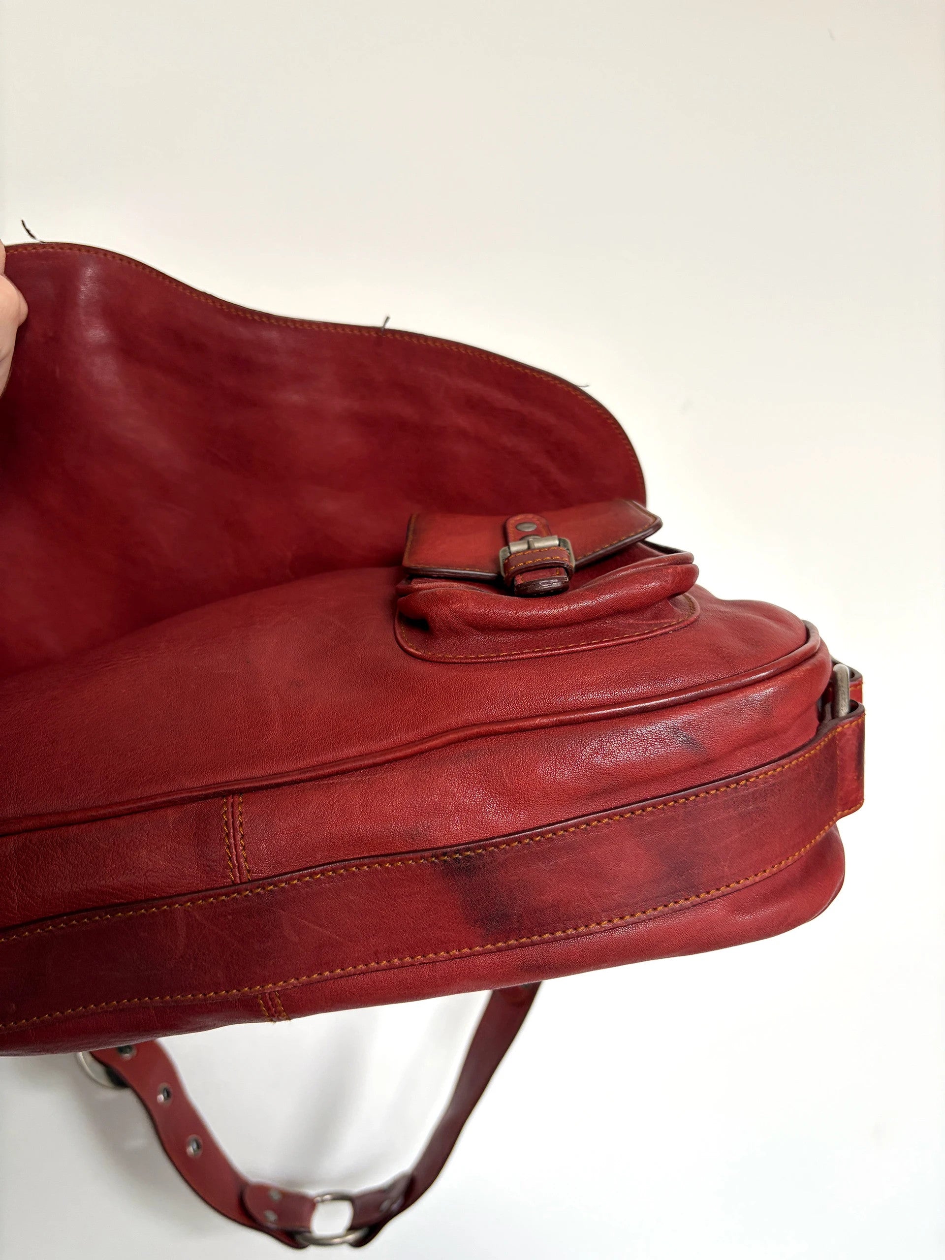 Christian Dior burgundy shoulder bag distressed calfskin leather with tan whipstitch and logo charms.