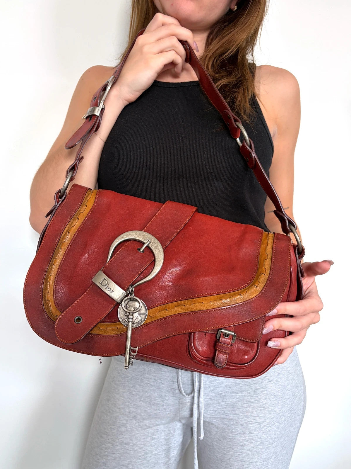 Christian Dior burgundy shoulder bag distressed calfskin leather with tan whipstitch and logo charms.