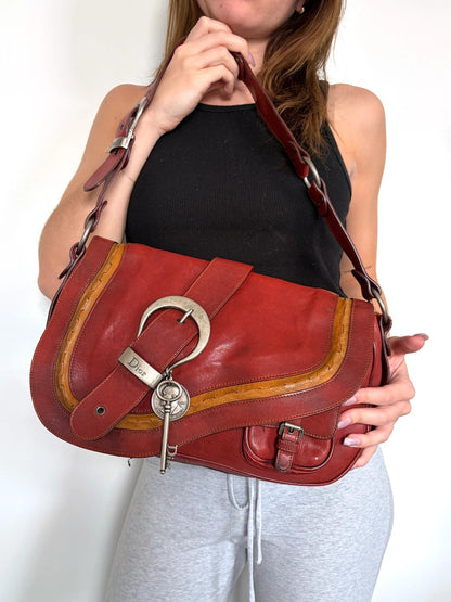 Christian Dior burgundy shoulder bag distressed calfskin leather with tan whipstitch and logo charms.