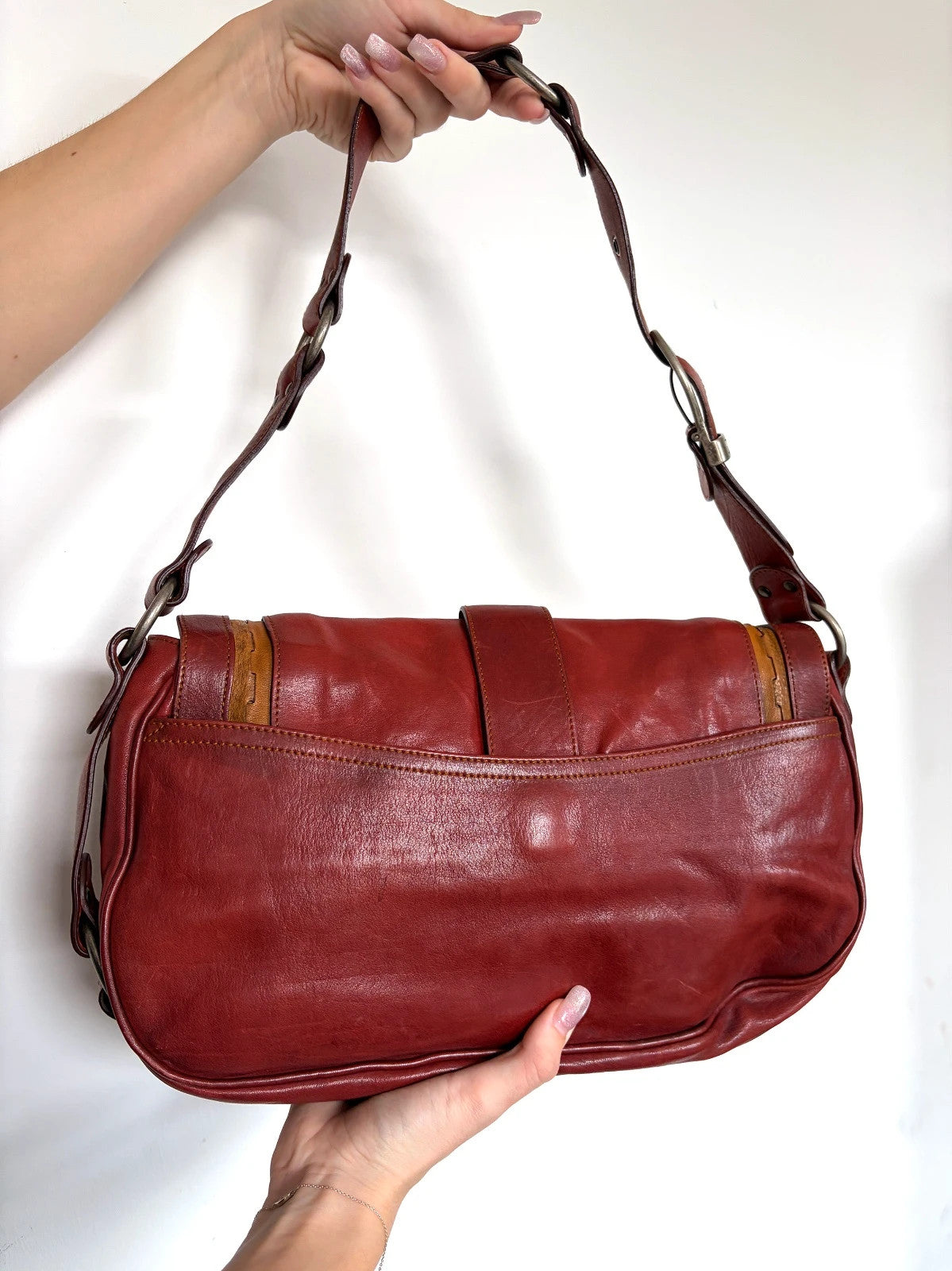 Christian Dior burgundy shoulder bag distressed calfskin leather with tan whipstitch and logo charms.