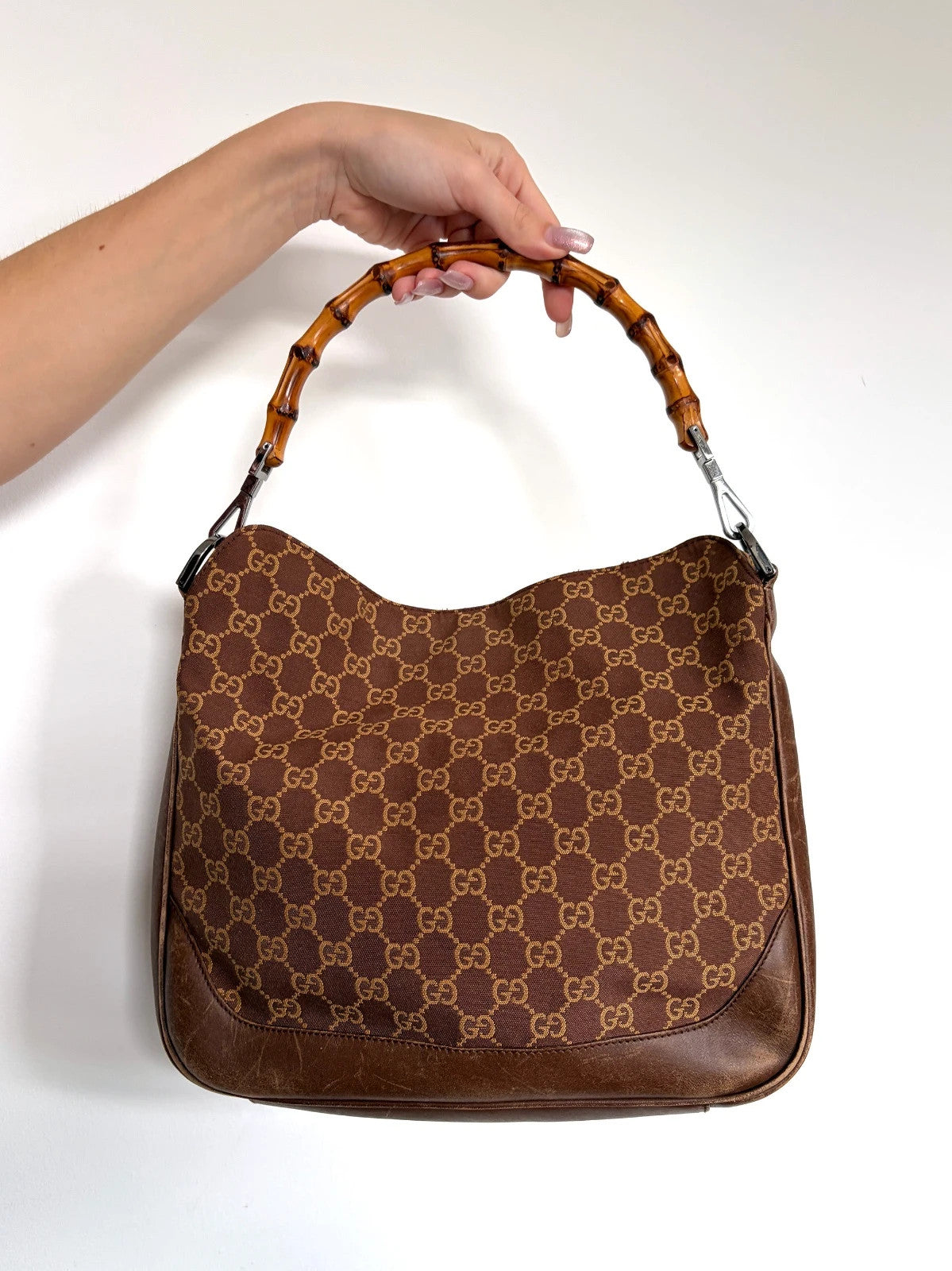 Gucci brown hobo bag with GG monogram canvas and bamboo handle, silver-tone hardware.