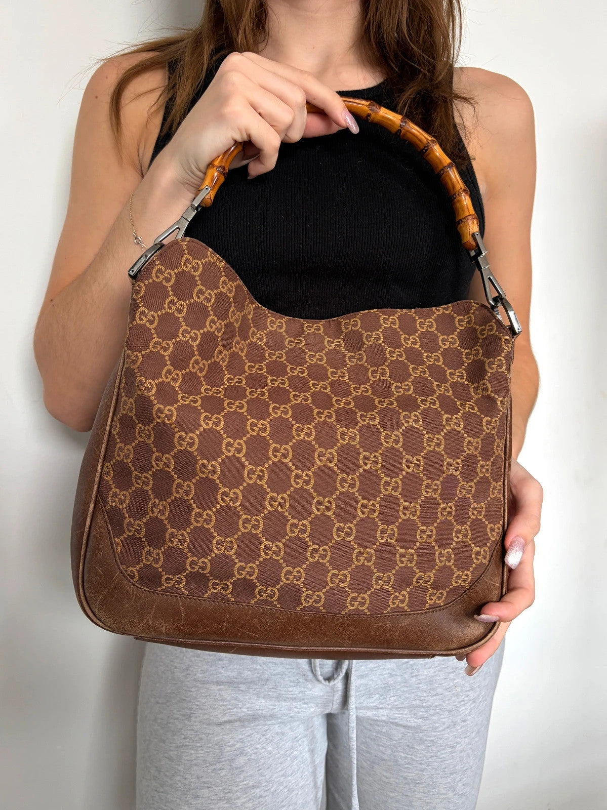 Gucci brown hobo bag with GG monogram canvas and bamboo handle, silver-tone hardware.