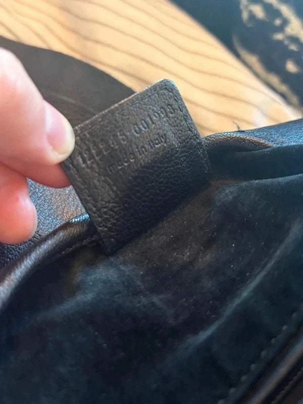Yves Saint Laurent black leather messenger bag with gold-tone logo plaque and textured panels.