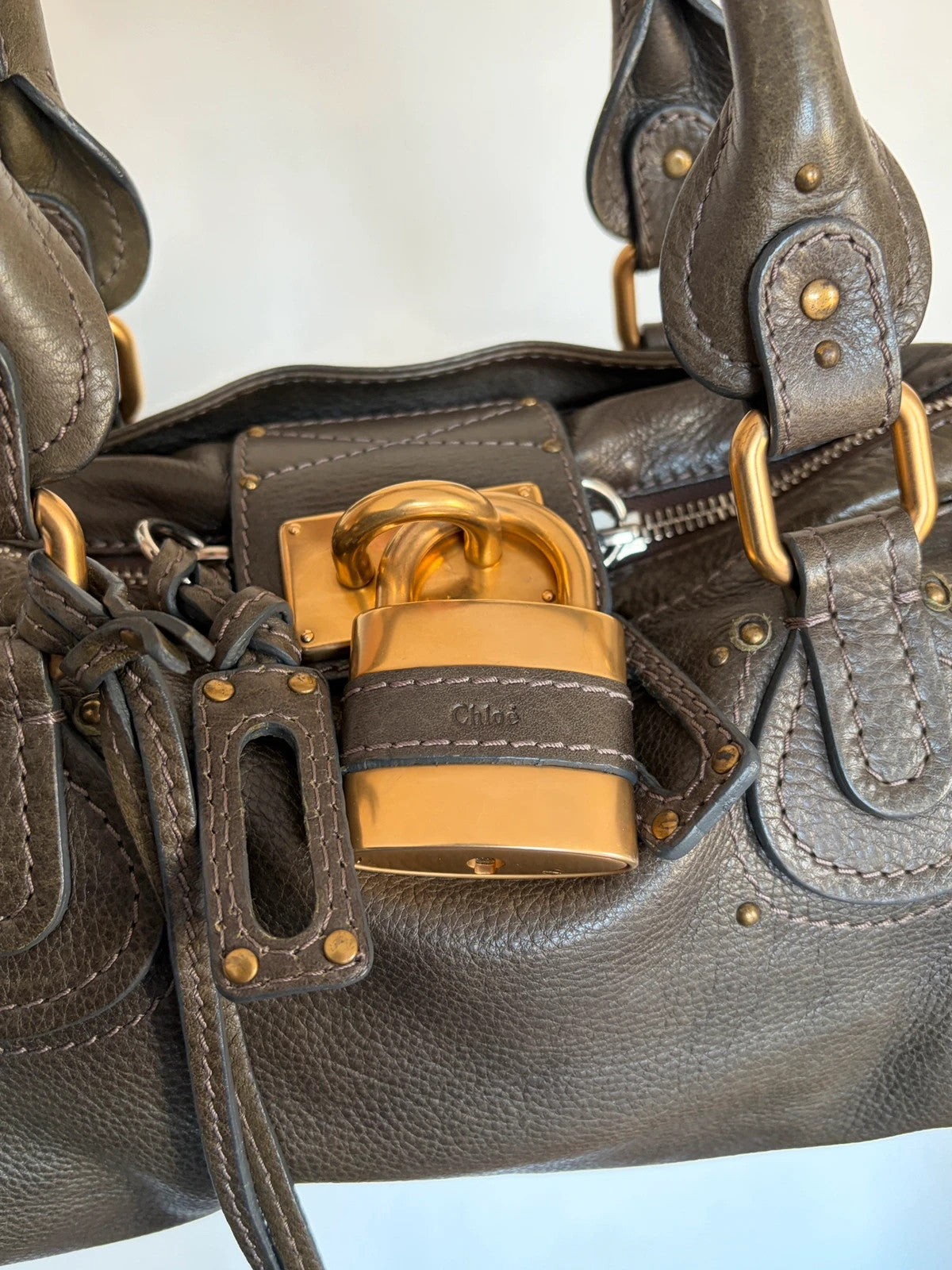 Chloé green leather Paddington bag with brass hardware and engraved padlock detail.