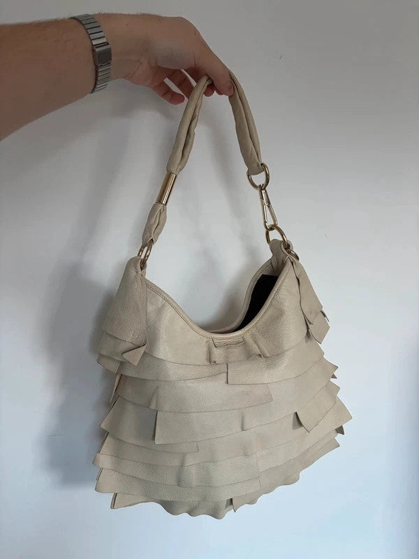 Yves Saint Laurent cream leather hobo bag with tiered ruffles and gold-tone logo plaque.