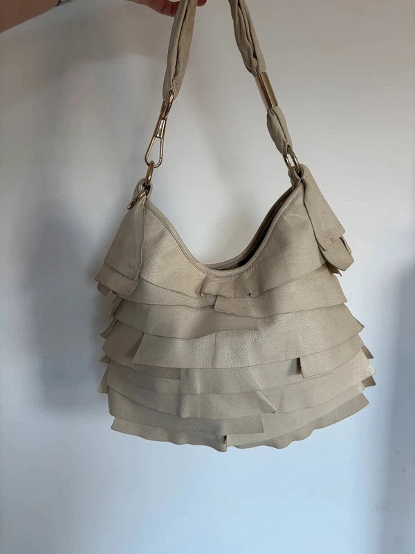 Yves Saint Laurent cream leather hobo bag with tiered ruffles and gold-tone logo plaque.