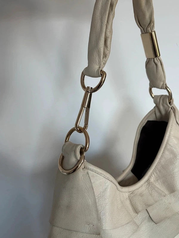Yves Saint Laurent cream leather hobo bag with tiered ruffles and gold-tone logo plaque.
