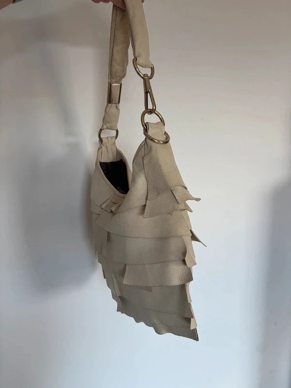 Yves Saint Laurent cream leather hobo bag with tiered ruffles and gold-tone logo plaque.