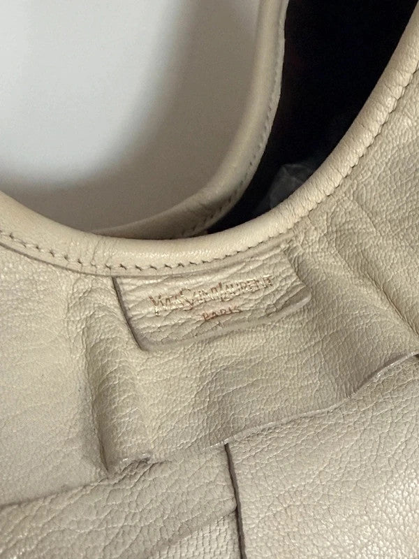 Yves Saint Laurent cream leather hobo bag with tiered ruffles and gold-tone logo plaque.