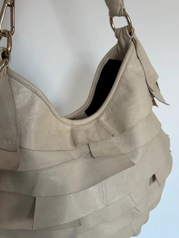 Yves Saint Laurent cream leather hobo bag with tiered ruffles and gold-tone logo plaque.
