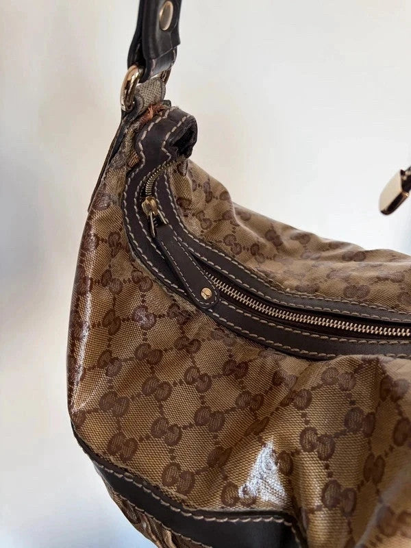 Gucci beige hobo bag with GG crystal monogram, dark brown leather trim, and gold-tone studs.