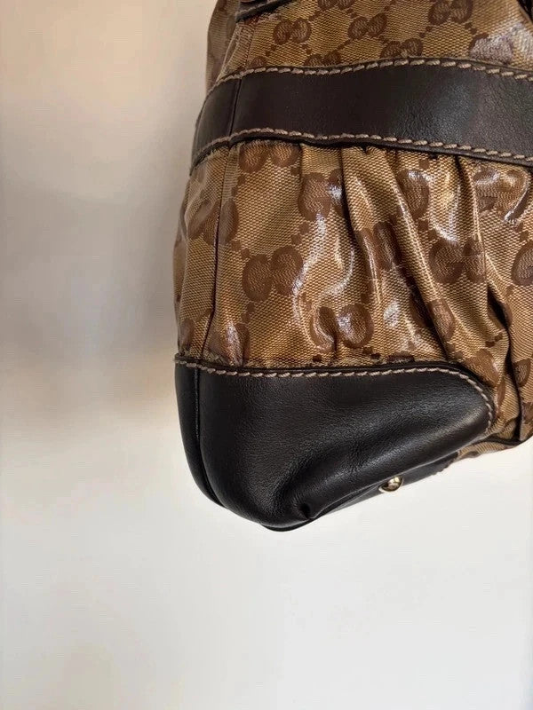 Gucci beige hobo bag with GG crystal monogram, dark brown leather trim, and gold-tone studs.
