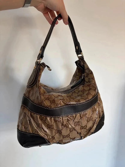 Gucci beige hobo bag with GG crystal monogram, dark brown leather trim, and gold-tone studs.