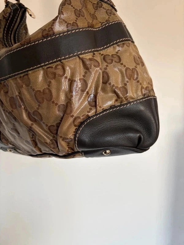 Gucci beige hobo bag with GG crystal monogram, dark brown leather trim, and gold-tone studs.
