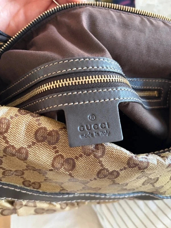 Gucci beige hobo bag with GG crystal monogram, dark brown leather trim, and gold-tone studs.