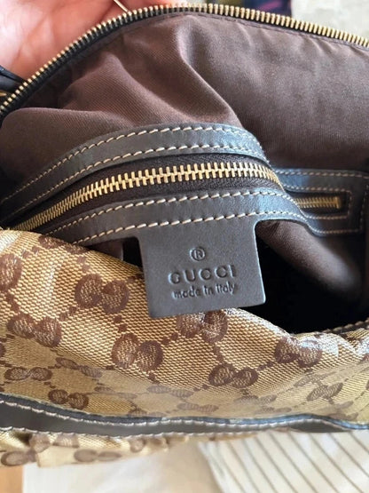Gucci beige hobo bag with GG crystal monogram, dark brown leather trim, and gold-tone studs.