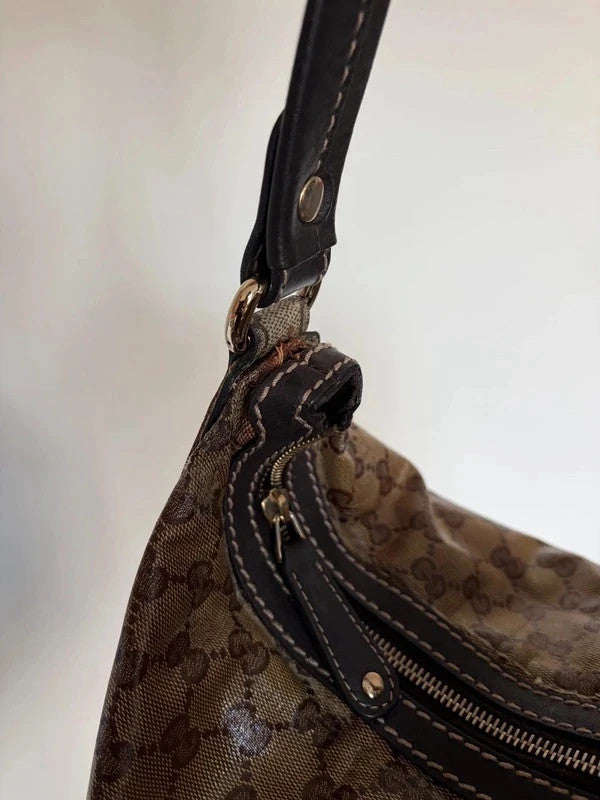 Gucci beige hobo bag with GG crystal monogram, dark brown leather trim, and gold-tone studs.