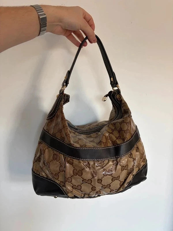 Gucci beige hobo bag with GG crystal monogram, dark brown leather trim, and gold-tone studs.