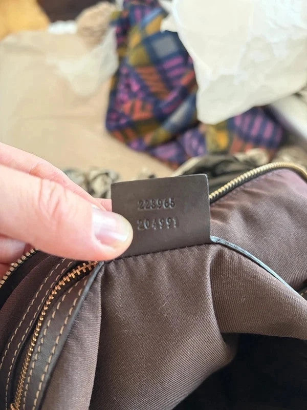 Gucci beige hobo bag with GG crystal monogram, dark brown leather trim, and gold-tone studs.