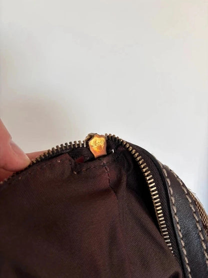 Gucci beige hobo bag with GG crystal monogram, dark brown leather trim, and gold-tone studs.