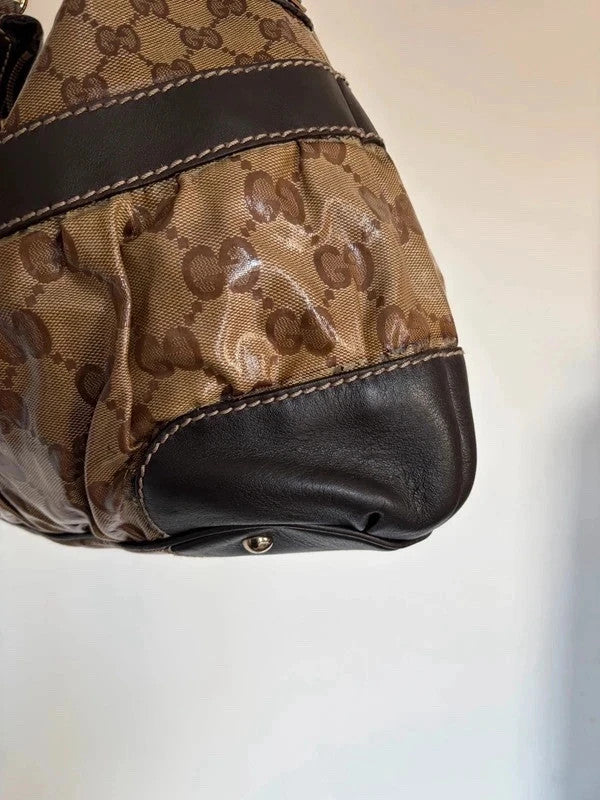 Gucci beige hobo bag with GG crystal monogram, dark brown leather trim, and gold-tone studs.