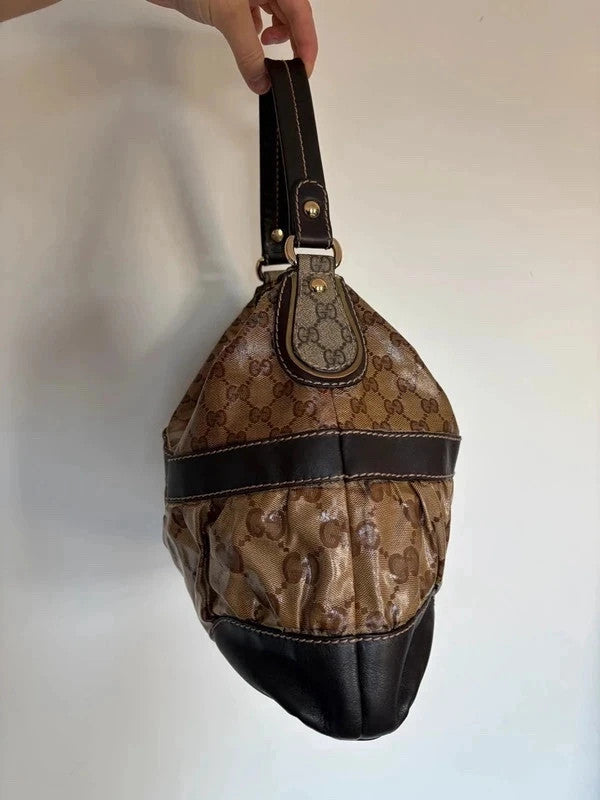 Gucci beige hobo bag with GG crystal monogram, dark brown leather trim, and gold-tone studs.