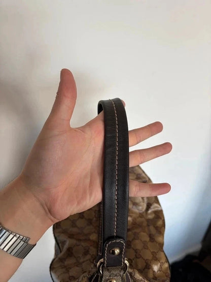 Gucci beige hobo bag with GG crystal monogram, dark brown leather trim, and gold-tone studs.