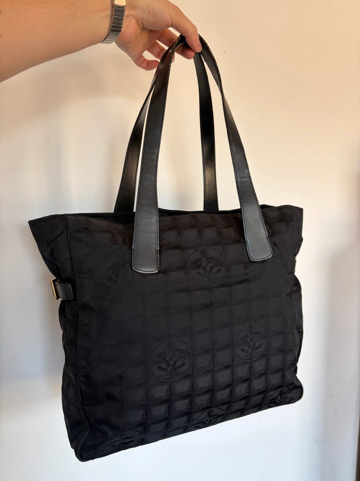 Chanel black shopping tote with CC jacquard pattern and leather shoulder handles.