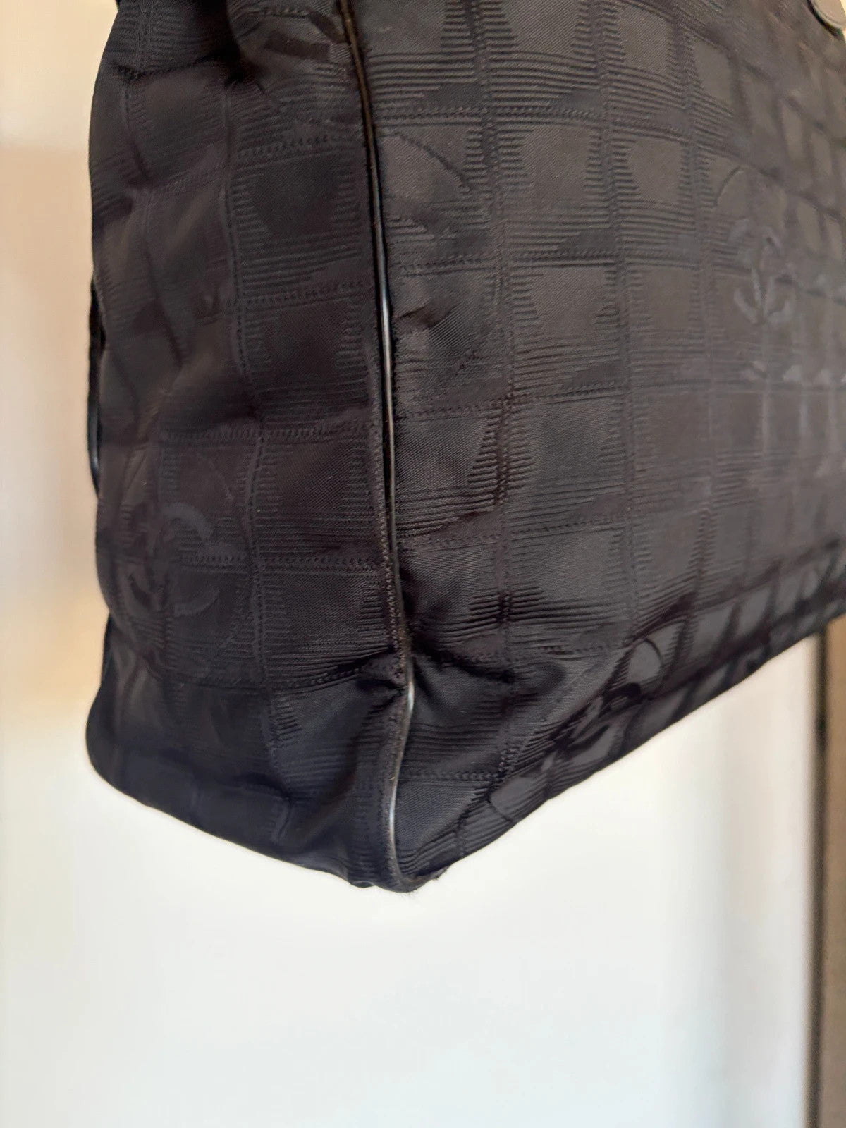 Chanel black shopping tote with CC jacquard pattern and leather shoulder handles.