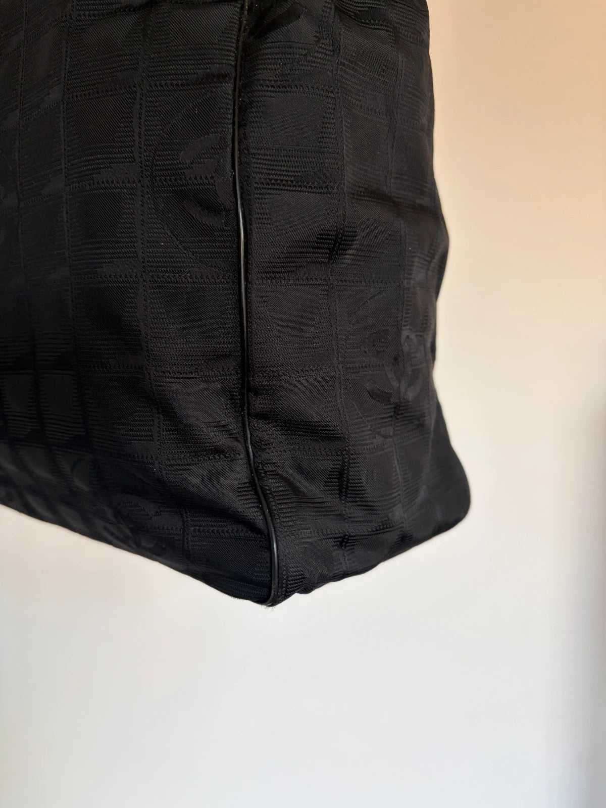 Chanel black shopping tote with CC jacquard pattern and leather shoulder handles.