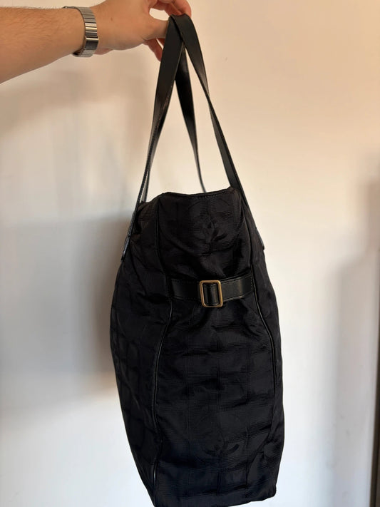 Chanel black shopping tote with CC jacquard pattern and leather shoulder handles.