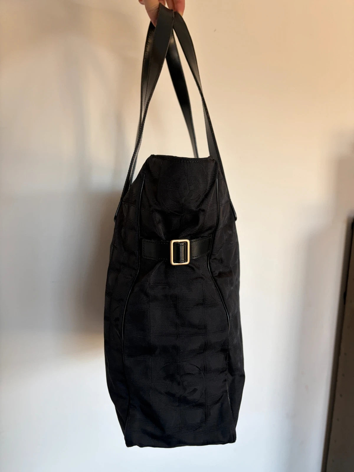 Chanel black shopping tote with CC jacquard pattern and leather shoulder handles.