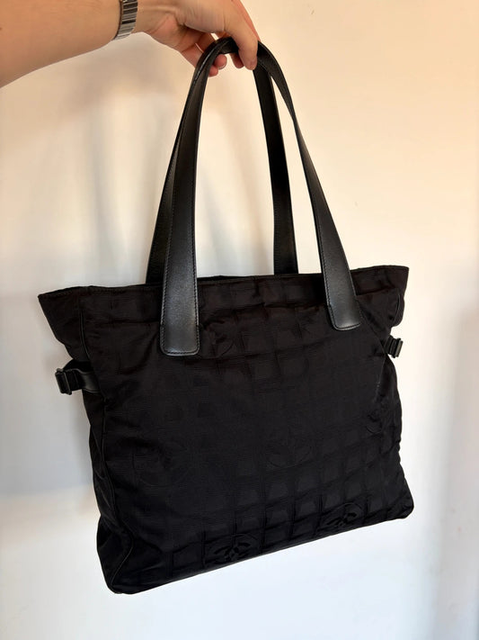 Chanel black shopping tote with woven CC jacquard pattern and smooth calfskin handles.