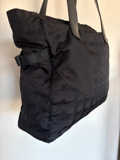 Chanel black shopping tote with woven CC jacquard pattern and smooth calfskin handles.