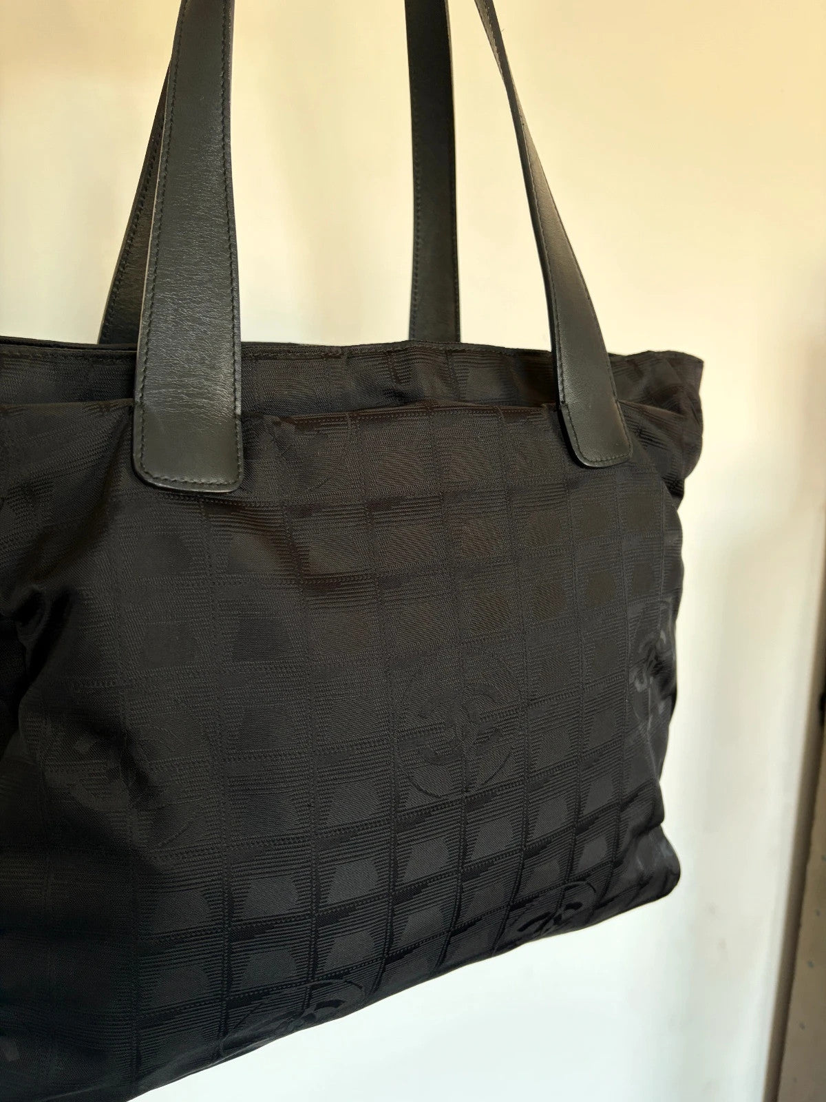 Chanel black shopping tote with woven CC jacquard pattern and smooth calfskin handles.
